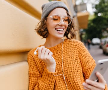 A smiling girl holding her cell phone and looks at it