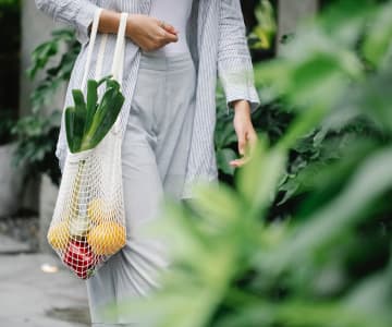 A woman holding a bag of veggies